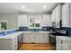 Bright kitchen with white cabinets, stainless steel appliances, undermount sink and blue backsplash at 138 Montibello Dr, Mooresville, NC 28117