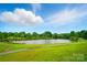 A picturesque view of a pond with a walking path, surrounded by lush greenery and a clear blue sky at 138 Montibello Dr, Mooresville, NC 28117