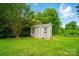 Charming gray storage shed surrounded by lush greenery, offering practical storage space at 138 Montibello Dr, Mooresville, NC 28117