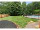 View of the backyard featuring a pool with fencing and lush greenery and a brick pathway at 144 Sea Trail Dr, Mooresville, NC 28117