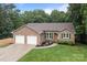 Attractive brick home with two-car garage, green shutters, and beautiful front garden at 144 Sea Trail Dr, Mooresville, NC 28117