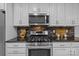 Well-equipped kitchen featuring stainless steel gas range, microwave, granite counters and white cabinetry at 144 Sea Trail Dr, Mooresville, NC 28117