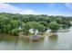 Aerial view of the lake with a wooden dock, boat ramp, and surrounding green trees in a serene environment at 144 Sea Trail Dr, Mooresville, NC 28117