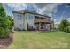 Expansive backyard featuring a spacious deck, covered patio, and lush greenery at 14503 Crest Ct, Charlotte, NC 28278