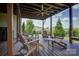 A covered backyard deck boasts ample seating and a ceiling fan for comfortable outdoor relaxation at 14503 Crest Ct, Charlotte, NC 28278