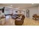 Open-concept living room with hardwood floors, leather sofas, billiards table, and a vintage clock at 14503 Crest Ct, Charlotte, NC 28278