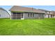 A backyard features a lush lawn, screened-in porch, and a home with gray siding and ample windows at 1528 Croydon St, Indian Land, SC 29707