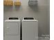 The laundry room features a modern washer and dryer with shelving for storage at 1541 Croydon St, Indian Land, SC 29707