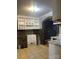 Kitchen view featuring tile floors, stone accent wall, white shelving, and granite countertops at 157 5Th N Ave, Taylorsville, NC 28681