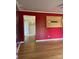 Spacious living room showcasing bamboo floors, complemented by bold red walls, white trim and view to the entry at 157 5Th N Ave, Taylorsville, NC 28681
