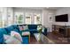 Bright living room featuring modern decor, large windows, and a plush blue sectional sofa at 1707 Cannon View Ln, Charlotte, NC 28208