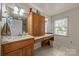 Bathroom with double sinks, wood cabinets, and a window providing natural light at 1818 Winfield Dr, Monroe, NC 28110