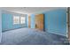 Bedroom with blue walls, blue carpet, featuring natural light and multiple doors at 1818 Winfield Dr, Monroe, NC 28110