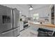 The bright kitchen features stainless steel appliances, white cabinets and tile flooring at 1818 Winfield Dr, Monroe, NC 28110