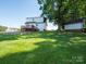 Expansive backyard showcasing mature trees, storage shed, and a well-maintained lawn at 1918 Gables Dr, Monroe, NC 28112