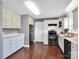 Kitchen featuring white cabinets, black appliances, and warm wood floors at 1918 Gables Dr, Monroe, NC 28112