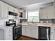 Close-up view of the kitchen with white cabinets and stainless steel dishwasher at 1918 Gables Dr, Monroe, NC 28112