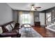 Living room featuring a large window, dark hardwood floors and a brown leather sofa at 1918 Gables Dr, Monroe, NC 28112