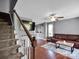 Carpeted stairs leading to a living room featuring a large TV and leather sofa at 1918 Gables Dr, Monroe, NC 28112