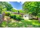 View of the home's backyard with storage building, lush landscaping and mature trees at 2001 Lakeview Dr, Pineville, NC 28134