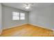 Bedroom featuring hardwood floors, a ceiling fan and neutral gray walls and white trim at 2001 Lakeview Dr, Pineville, NC 28134