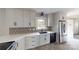 Renovated kitchen featuring white cabinets, stainless steel appliances, modern hardware, and a decorative backsplash at 2001 Lakeview Dr, Pineville, NC 28134