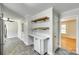 Eat-in kitchen with floating shelves, built in desk, updated cabinets, and contrasting gray flooring at 2001 Lakeview Dr, Pineville, NC 28134