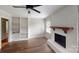 Bright living room featuring a decorative fireplace, hardwood floors, a ceiling fan, and built-in shelving at 2001 Lakeview Dr, Pineville, NC 28134