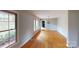 Open concept living room with hardwood floors, large windows, neutral paint, and minimalist decor at 2001 Lakeview Dr, Pineville, NC 28134