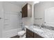 Bright bathroom featuring a shower-tub combo, granite countertop, and wood-grain cabinets at 206 Overstone Ct, Fort Mill, SC 29715