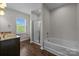 Bright bathroom featuring double vanity, soaking tub, and separate glass enclosed shower at 206 Overstone Ct, Fort Mill, SC 29715