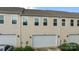 Townhome featuring attached garage and street parking, complemented by well-maintained lawn and ornamental grasses at 206 Overstone Ct, Fort Mill, SC 29715