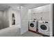 Convenient laundry room featuring modern appliances and additional storage shelving at 206 Overstone Ct, Fort Mill, SC 29715