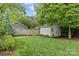 Lush backyard with a putting green, a white storage shed, and a privacy fence, ideal for outdoor activities at 2615 Chesterfield Ave, Charlotte, NC 28205