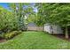 Lush backyard featuring a putting green, a storage shed, and mature trees, providing a serene outdoor space at 2615 Chesterfield Ave, Charlotte, NC 28205