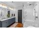 Bright bathroom featuring a double vanity, marble countertops, and a glass-enclosed shower with herringbone tile at 2615 Chesterfield Ave, Charlotte, NC 28205