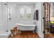 Elegant bathroom featuring a freestanding tub and a glass-enclosed shower, complemented by hardwood floors at 2615 Chesterfield Ave, Charlotte, NC 28205