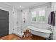 Bright bathroom with a glass-enclosed shower and a freestanding tub, accented by hardwood floors and natural light at 2615 Chesterfield Ave, Charlotte, NC 28205