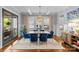 Stylish dining room with hardwood floors, modern chandelier, paneled walls, and view to the kitchen at 2615 Chesterfield Ave, Charlotte, NC 28205