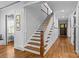Hallway with hardwood floors, a staircase with white risers, and a wood railing at 2615 Chesterfield Ave, Charlotte, NC 28205