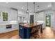 Stylish kitchen with a large island, wooden countertop, white cabinets, and modern pendant lighting at 2615 Chesterfield Ave, Charlotte, NC 28205