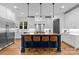 Bright kitchen with stainless steel appliances, white cabinets, a wooden island with seating, and modern pendant lighting at 2615 Chesterfield Ave, Charlotte, NC 28205