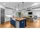 Open-concept kitchen featuring a large island, farmhouse sink, stainless steel appliances, and seamless flow to the living room at 2615 Chesterfield Ave, Charlotte, NC 28205