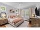 Comfortable main bedroom with plush bedding, soft lighting, hardwood floors, and large windows at 2615 Chesterfield Ave, Charlotte, NC 28205
