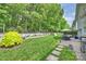 Beautiful backyard with a stone patio, lush lawn, and mature trees creates a serene outdoor space at 2630 Mary Butler Way, Charlotte, NC 28226