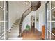 Grand foyer featuring a curved staircase, hardwood floors, and elegant chandelier lighting at 2630 Mary Butler Way, Charlotte, NC 28226