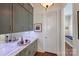 Hallway featuring gray cabinets, mirror backsplash, marble countertop, and a door leading to a bench seating area at 2630 Mary Butler Way, Charlotte, NC 28226
