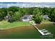 Expansive lakefront property with a modern home, pool, lush landscaping, and private boat dock at 301 Riverwood Rd, Mooresville, NC 28117