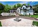 Backyard featuring a stone patio with a fire pit and steps up to the rear of the house at 301 Riverwood Rd, Mooresville, NC 28117