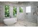 Bright bathroom featuring a modern soaking tub, tiled walls, and walk-in shower with lake views from multiple windows at 301 Riverwood Rd, Mooresville, NC 28117